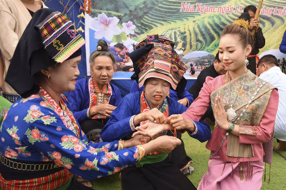 Nghi thức buộc chỉ cổ tay cầu may, chúc phúc cho người được buộc chỉ một năm mới bình an, không ốm đau bệnh tật. (Ảnh: Xuân Tư/TTXVN)
