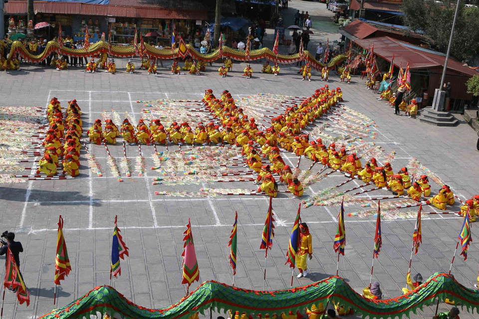  Các thanh niên nam nữ tiến hành xếp chữ trong Lễ hội Phủ Dầy. (Ảnh: Công Luật/TTXVN)