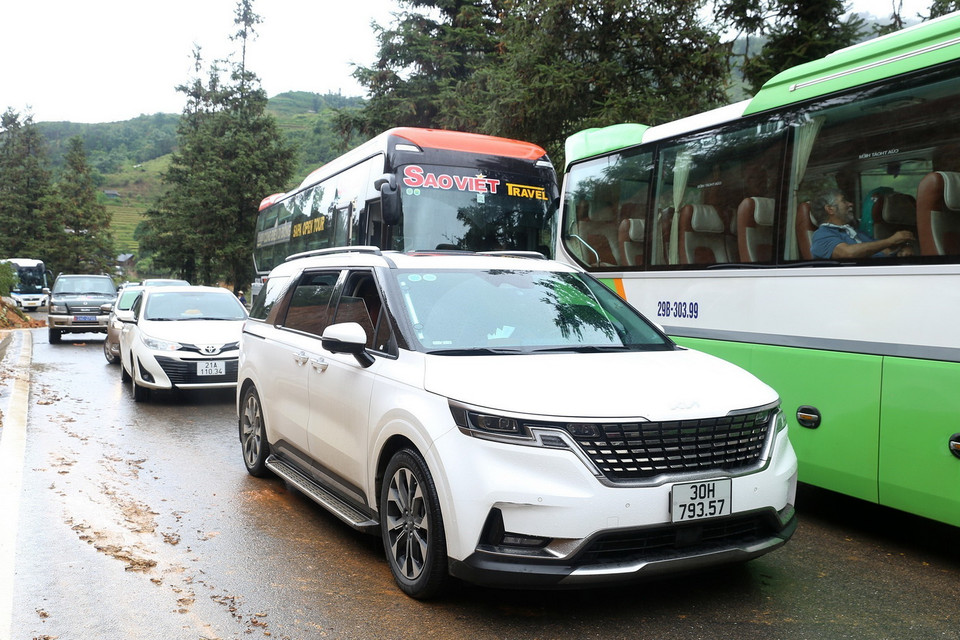 Các phương tiện tham gia giao thông trên Quốc lộ 4D đoạn qua địa phận phường Hàm Rồng, thị xã Sa Pa, tỉnh Lào Cai, không thể lưu thông do sạt lở đất đá xuống lòng đường. (Ảnh: Quốc Khánh/TTXVN)