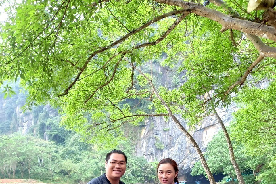 Du khách vui mừng và bày tỏ sự cảm ơn khi được nhân viên Trung tâm Du lịch Phong Nha-Kẻ Bàng trao trả lại tài sản bị quên, thất lạc. (Ảnh: TTXVN phát)