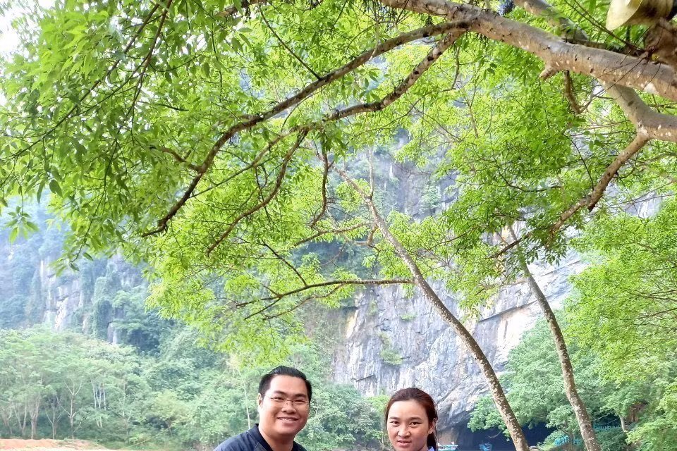Du khách vui mừng và bày tỏ sự cảm ơn khi được nhân viên Trung tâm Du lịch Phong Nha-Kẻ Bàng trao trả lại tài sản bị quên, thất lạc. (Ảnh: TTXVN phát)