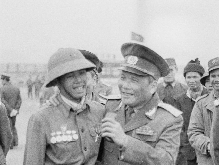 Đại tướng Chu Huy Mân khen ngợi chiến sỹ Hoàng Văn Nhằm, xã đội trưởng xã Oai Ninh, huyện Hữu Lũng (Lạng Sơn) 8 năm liền đạt danh hiệu chiến sỹ quyết thắng có thành tích trong chiến đấu chiến tranh biên giới phía Bắc (1984). (Ảnh: Minh Điền/TTXVN)