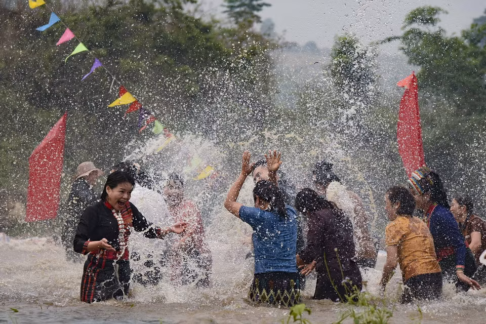  Đông đảo bà con dân bản và du khách cùng nhau ra suối vẩy nước vào nhau với mong muốn mọi người gặp nhiều may mắn. (Ảnh: Xuân Tư/TTXVN)