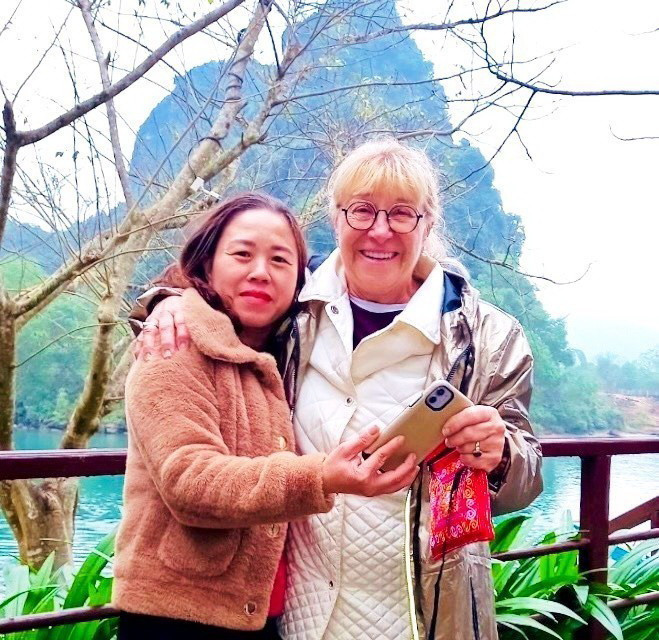 Chị Nguyễn Thị Cương (trái) thợ nhiếp ảnh thuộc Đội ảnh Trung tâm Du lịch Phong Nha-Kẻ Bàng đã từng nhặt được tài sản của du khách để quên. (Ảnh: TTXVN phát)