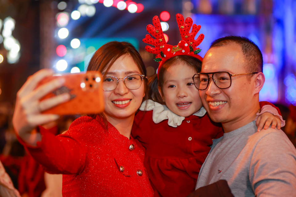 Nhiều gia đình mang trẻ nhỏ đi đón Giáng sinh. (Ảnh: Minh Sơn/Vietnam+)