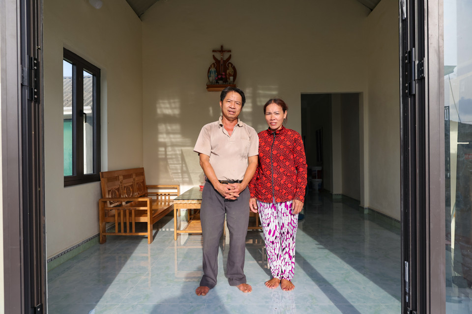 Ông Nguyên cùng vợ mình chia sẻ: 'Nhà được xây dựng cao và kiên cố, nước chỉ ngập vào chân sàn nhà khoảng 10cm, trong khi nếu so với nhà cũ sẽ ngập nửa nhà. Nhà mới có gác nên toàn bộ lúa của chúng tôi vừa thu hoạch không bị thiệt hại, không phải mang đồ đi gửi nhà hàng xóm như những năm trước nữa.' (Ảnh: Minh Sơn/Vietnam+)