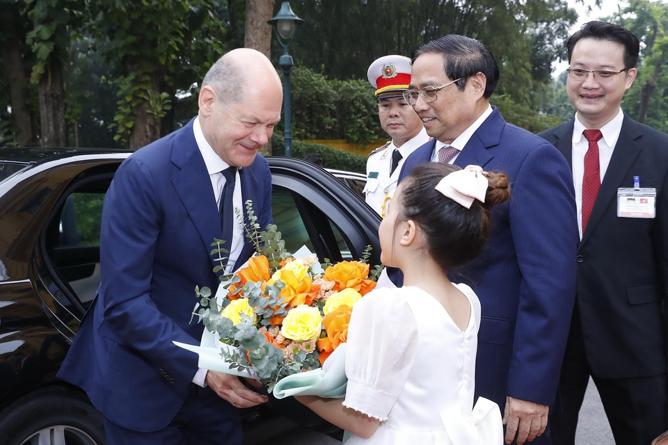 Thiếu nhi Hà Nội tặng hoa, chào mừng Thủ tướng Đức Olaf Scholz. (Ảnh: TTXVN)