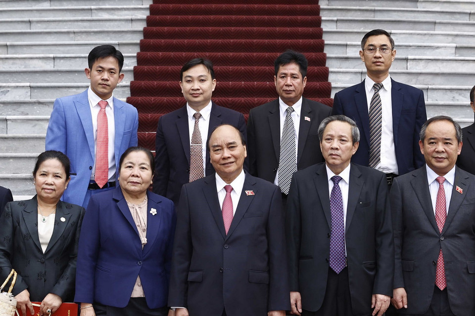 Chủ tịch nước Nguyễn Xuân Phúc và bà Sisay Leudetmounsone chụp ảnh chung với các đại biểu. (Ảnh: Thống Nhất/TTXVN)