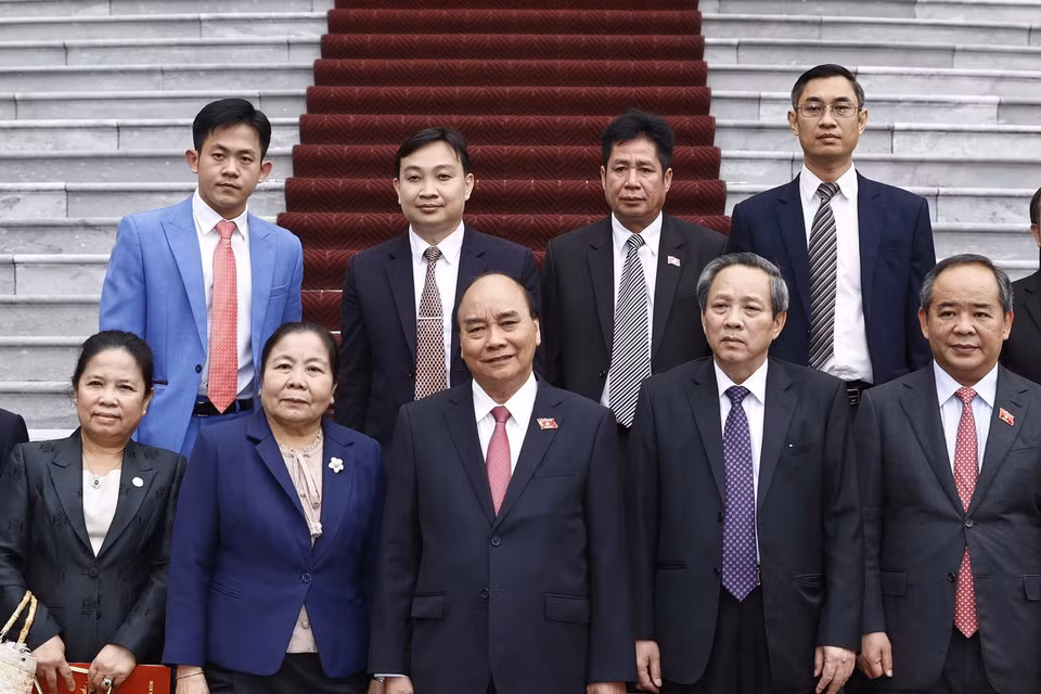 Chủ tịch nước Nguyễn Xuân Phúc và bà Sisay Leudetmounsone chụp ảnh chung với các đại biểu. (Ảnh: Thống Nhất/TTXVN)