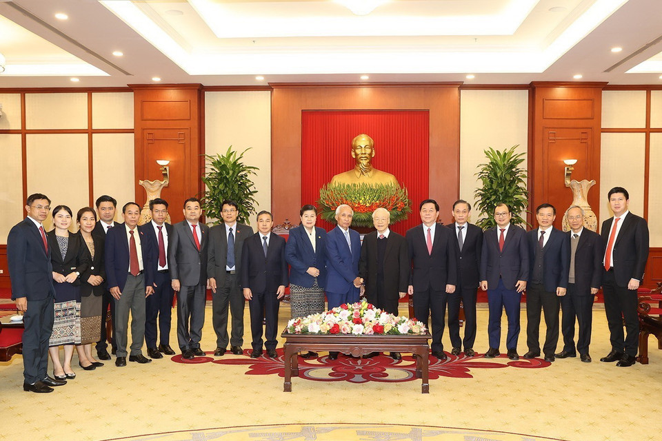  Tổng Bí thư Nguyễn Phú Trọng và ông Khamphan Pheuyavong, Bí thư Trung ương Đảng, Trưởng ban Tuyên huấn, Chủ tịch Hội đồng Lý luận Trung ương Đảng Nhân dân Cách mạng Lào cùng các đại biểu chụp ảnh chung. (Ảnh Trí Dũng/TTXVN)