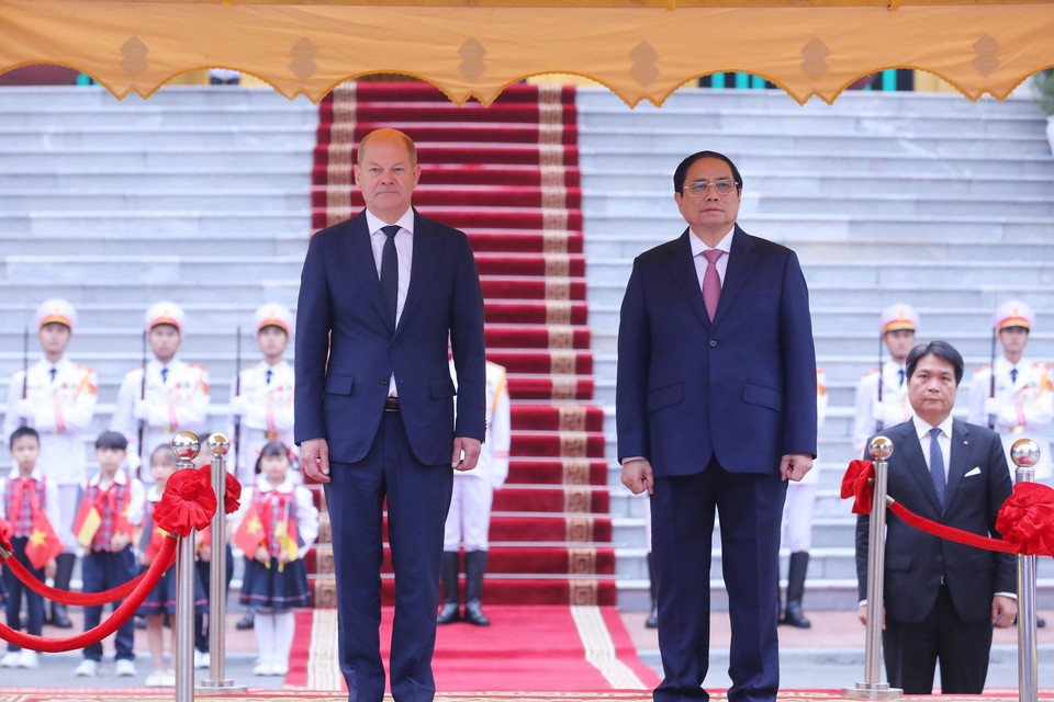 Thủ tướng Phạm Minh Chính và Thủ tướng Đức Olaf Scholz trên bục danh dự, nghe quân nhạc cử Quốc thiều hai nước. Ảnh: Lâm Khánh - TTXVN