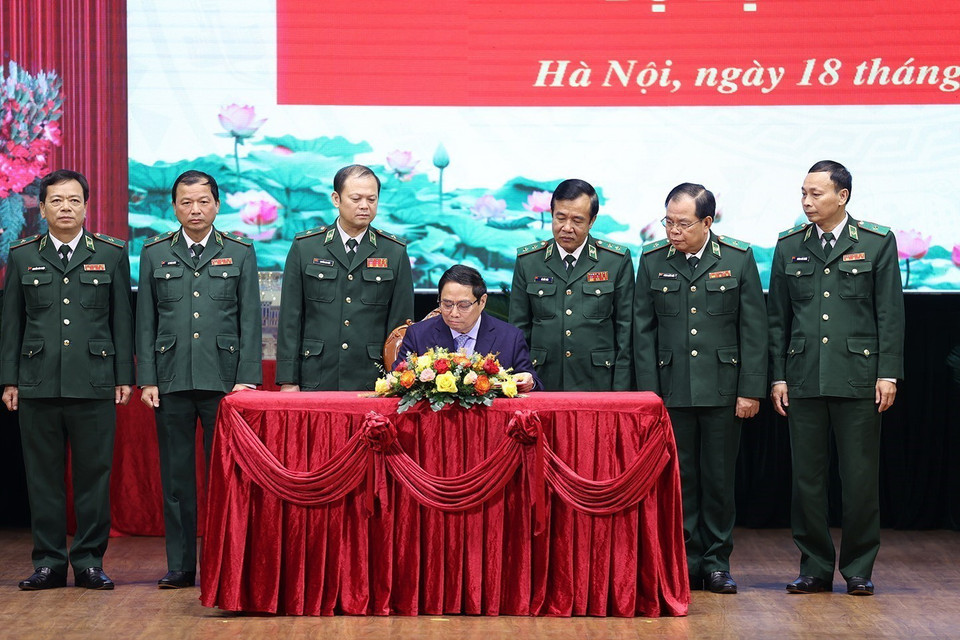 Thủ tướng Phạm Minh Chính viết sổ lưu niệm khi đến thăm và làm việc với Bộ Tư lệnh Bộ đội Biên phòng. (Ảnh: Dương Giang/TTXVN)