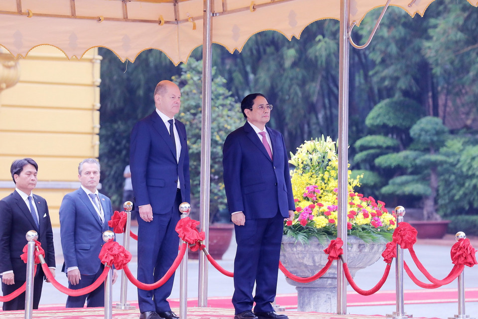 Thủ tướng Phạm Minh Chính và Thủ tướng Đức Olaf Scholz trên bục danh dự, nghe quân nhạc cử Quốc thiều hai nước. Ảnh: Lâm Khánh - TTXVN