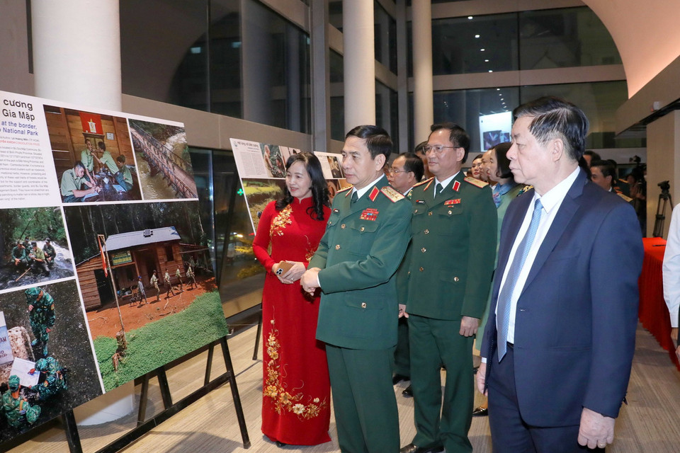 Đại tướng Phan Văn Giang, ông Nguyễn Trọng Nghĩa và các đại biểu tham quan triển lãm ảnh. (Ảnh: Phương Hoa/TTXVN)