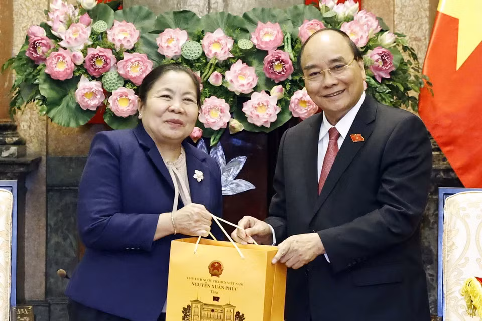 Chủ tịch nước Nguyễn Xuân Phúc tặng quà lưu niệm cho bà Sisay Leudetmounsone. (Ảnh: Thống Nhất/TTXVN)