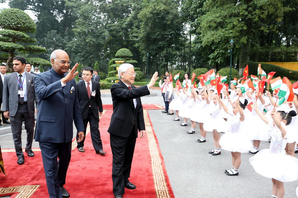 Tổng Bí thư, Chủ tịch nước Nguyễn Phú Trọng và Tổng thống Ấn Độ Ram Nath Kovind vẫy chào các cháu thiếu nhi Hà Nội tại lễ đón. (Ảnh: Trí Dũng/TTXVN)