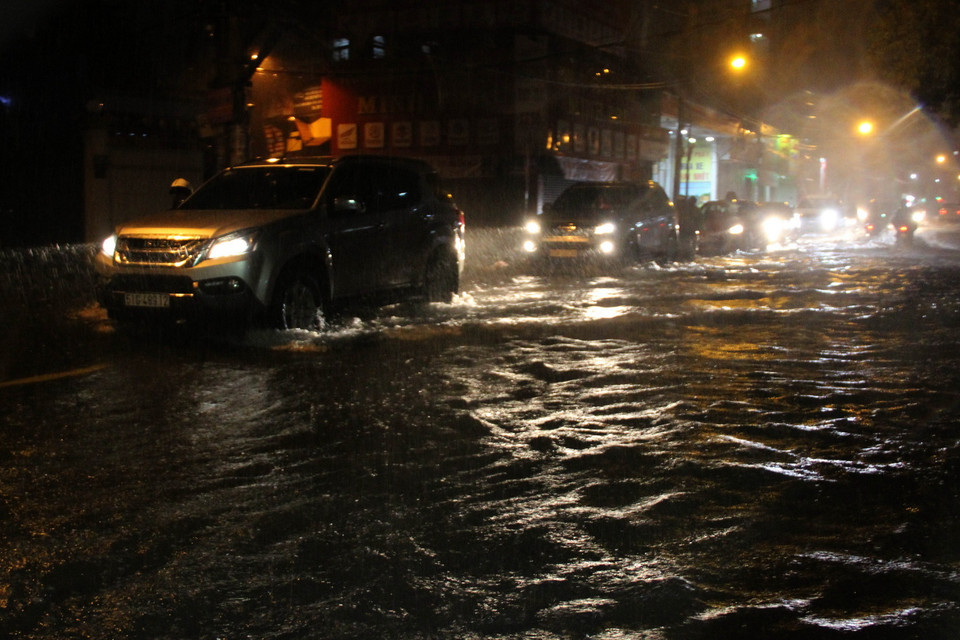 Các phương tiện lưu thông trong tình trạng ngập nước ở đường Lạc Long Quận, quận Tân Bình. (Ảnh: Xuân Dự/TTXVN)
