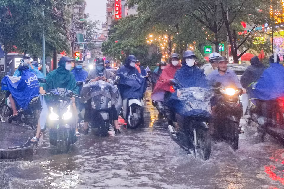 Mưa ngập khiến một số phương tiện di chuyển chậm hoặc phải tạm dừng. (Ảnh: Hoài Nam/Vietnam+)