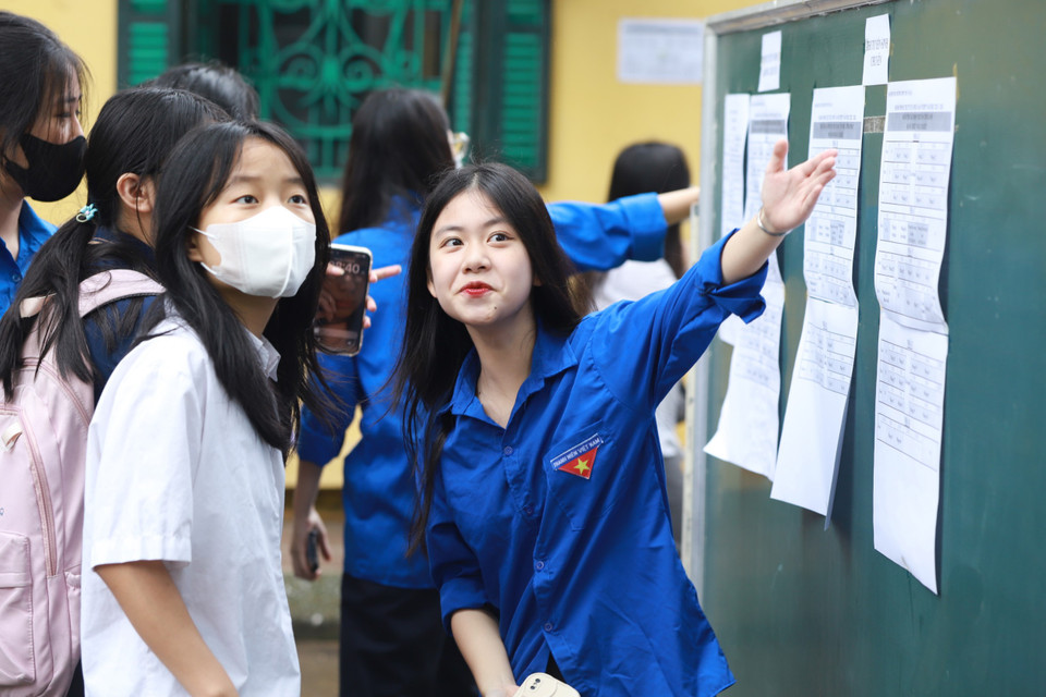 Tình nguyện viên hướng dẫn thí sinh tìm phòng thi để nghe quy chế. (Ảnh: PV/Vietnam+)