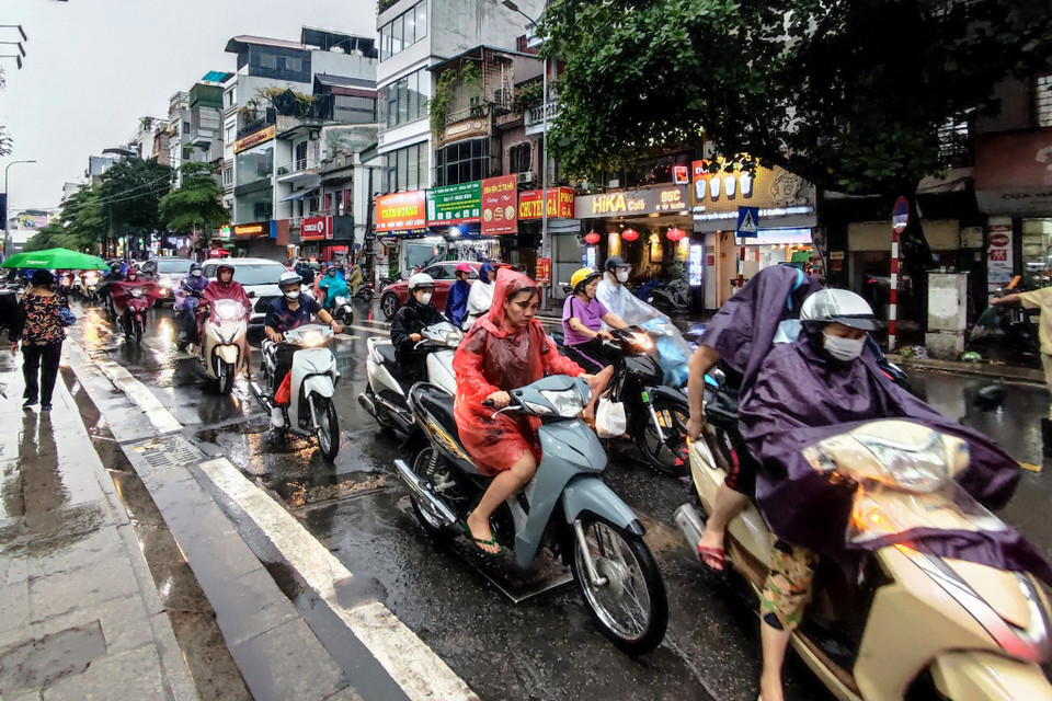Tại khu vực phố Khâm Thiên, người dân di chuyển chậm do ảnh hưởng của mưa lớn. (Ảnh: Hoài Nam/Vietnam+)