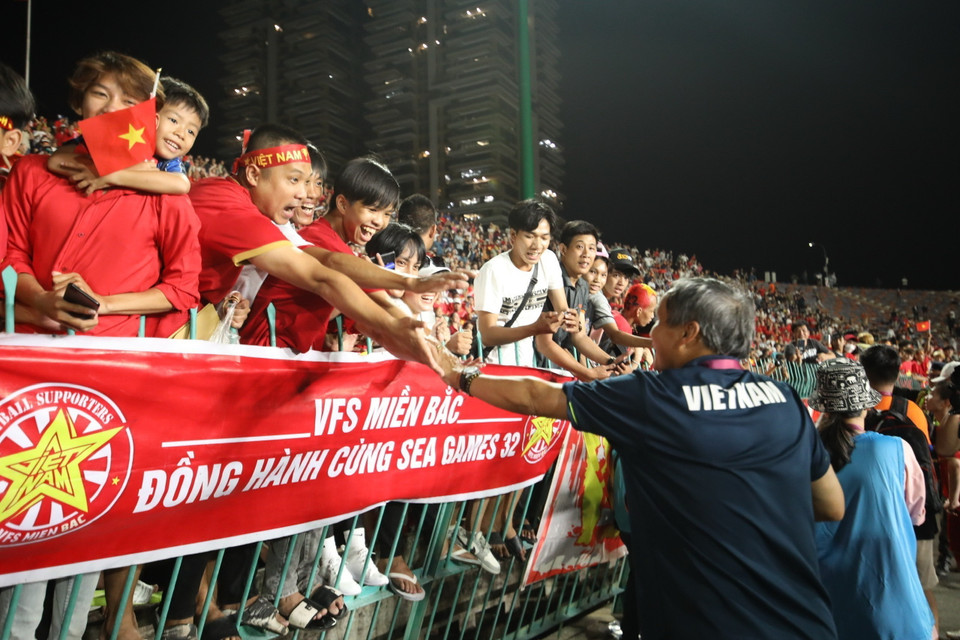 HLV Mai Đức Chung chia sẻ niềm vui với các CĐV sau khi đội Việt Nam giành chiến thắng. (Ảnh: Minh Quyết/TTXVN)