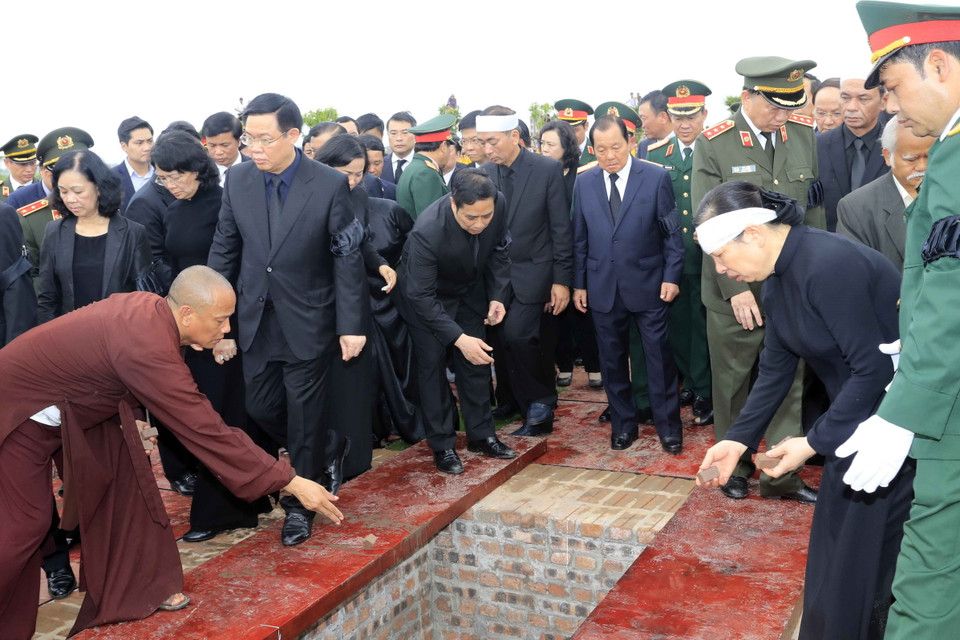 Lãnh đạo, nguyên lãnh đạo Đảng, Nhà nước, Mặt trận Tổ quốc Việt Nam và gia đình Chủ tịch nước Trần Đại Quang thả những nắm đất đầu tiên xuống huyệt mộ Chủ tịch nước. (Ảnh: Nhan Sáng/TTXVN)