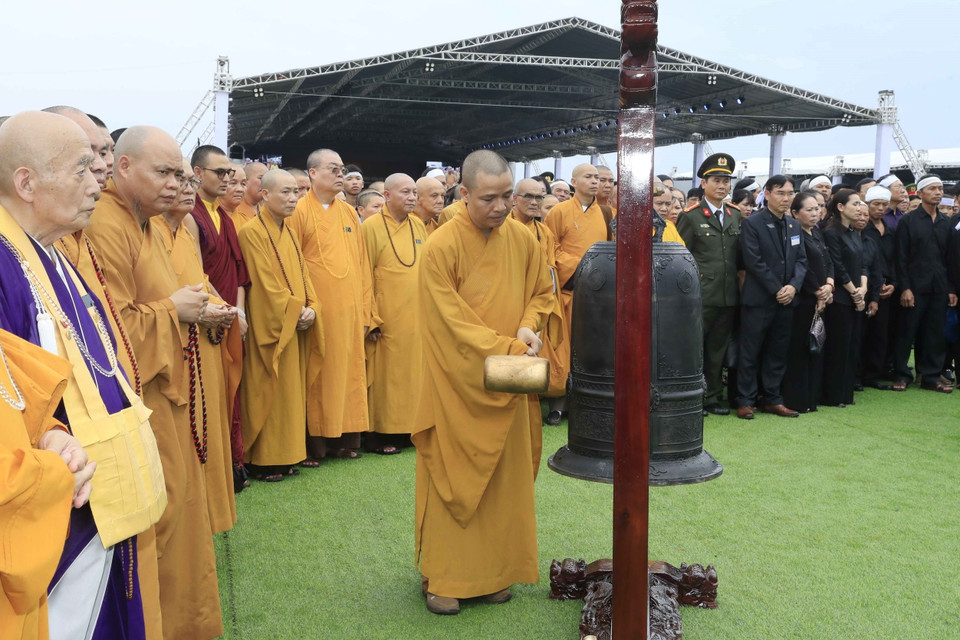 Các nhà sư thực hiện nghi thức thỉnh một hồi chuông dài, trước khi đội nghi lễ tiến hành lấp mộ Chủ tịch nước Trần Đại Quang. (Ảnh: Nhan Sáng/TTXVN)