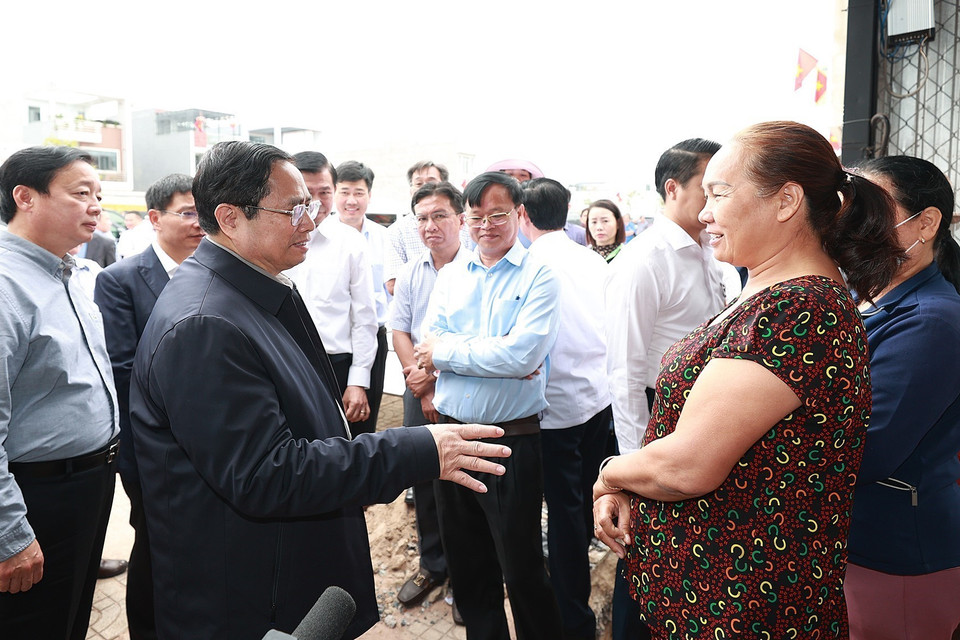 Thủ tướng Phạm Minh Chính trao đổi với người dân Khu tái định cư Dự án Cảng Hàng không Quốc tế Long Thành. (Ảnh: Dương Giang/TTXVN)