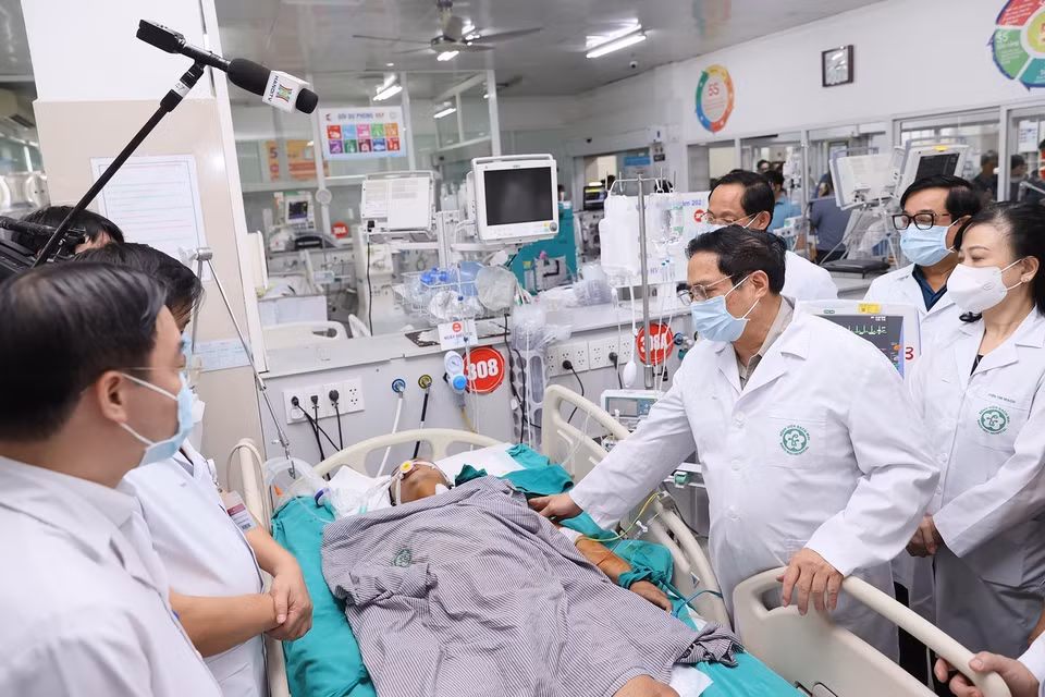 Thủ tướng Phạm Minh Chính thăm hỏi sức khỏe các nạn nhân đang điều trị tại Bệnh viện Bạch Mai. (Ảnh: Dương Giang/TTXVN)