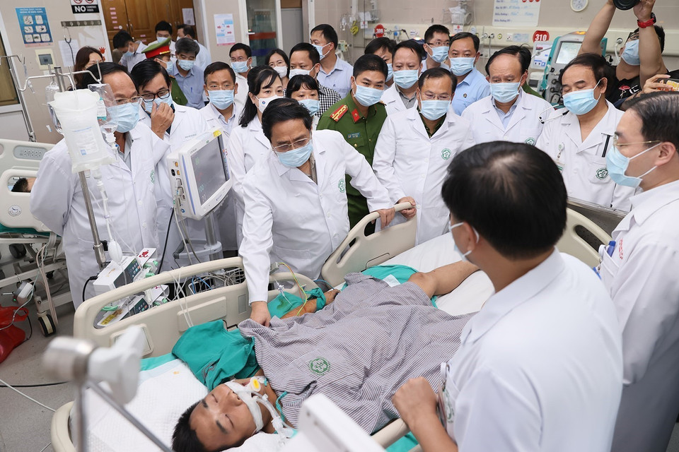 Thủ tướng Phạm Minh Chính thăm hỏi sức khỏe các nạn nhân đang điều trị tại Bệnh viện Bạch Mai. (Ảnh: Dương Giang/TTXVN)