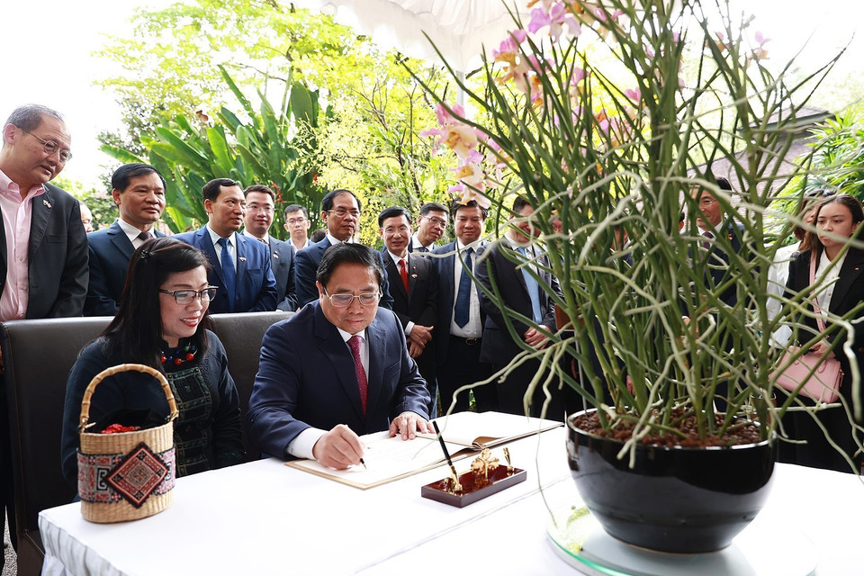 Thủ tướng Phạm Minh Chính ký sổ lưu niệm khi đến dự lễ đặt tên hoa lan tại Vườn Thực vật Singapore. (Ảnh: Dương Giang/TTXVN)