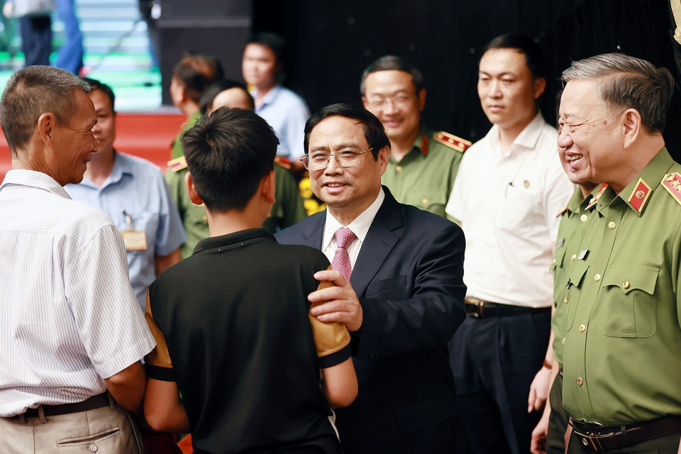 Thủ tướng Phạm Minh Chính động viên em Lường Quốc Bảo con của Đại úy, liệt sỹ Lường Phát Chiêm, Trung đội trưởng Phòng Cảnh sát bảo vệ và hỗ trợ tư pháp, Công an tỉnh Sơn La. (Ảnh: Dương Giang/TTXVN)