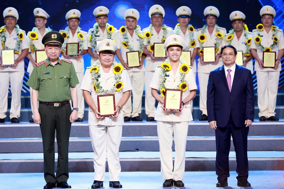 Thủ tướng Phạm Minh Chính và Đại tướng Tô Lâm trao biểu trưng vinh danh điển hình tiên tiến trong phòng, chống ma túy cho các cá nhân. (Ảnh: Dương Giang/TTXVN)