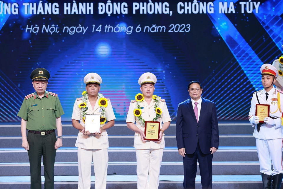 Thủ tướng Phạm Minh Chính và Đại tướng Tô Lâm, Bộ trưởng Bộ Công an trao biểu trưng vinh danh điển hình tiên tiến trong phòng, chống ma túy cho các cá nhân. (Ảnh: Dương Giang/TTXVN)