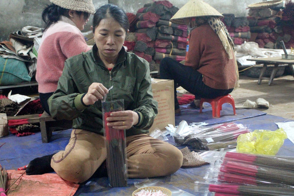 Nhiều người dân làm tăng ca để có hàng bán dịp Tết này. (Ảnh: Nguyễn Nam/TTXVN)