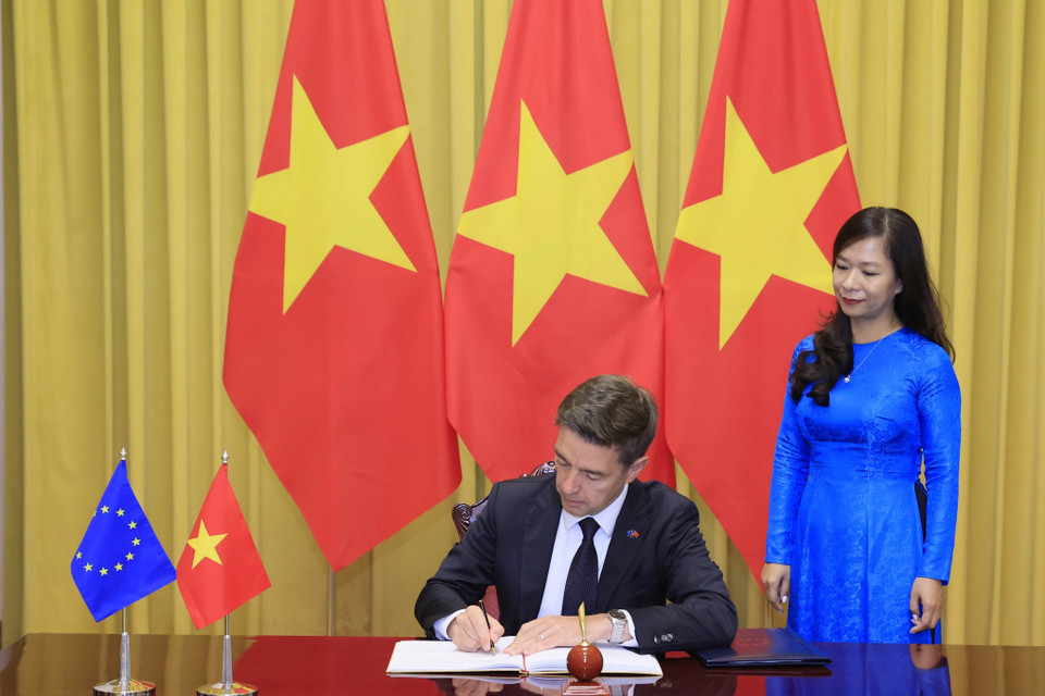 Đại sứ Liên minh châu Âu tại Việt Nam Julien Guerrier viết lưu bút tại lễ trình Quốc thư. (Ảnh: Thống Nhất/TTXVN)