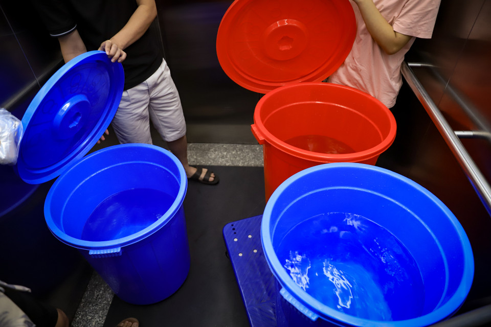 Chị Nhung, một cư dân, cho biết: ‘Người dân đều bảo nhau không lấy đầy để tránh vương vãi lãng phí và để dành cho người lấy sau.’ (Ảnh: Hoài Nam/Vietnam+)