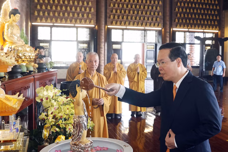 Chủ tịch nước Võ Văn Thưởng thực hiện nghi thức tắm Phật tại chùa Huê Nghiêm. (Ảnh: Thống Nhất/TTXVN)