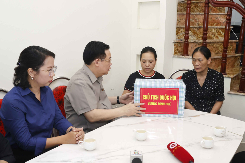 Chủ tịch Quốc hội Vương Đình Huệ thăm hỏi hộ dân sống liền kề chung cư mini lúc xảy ra vụ việc đã giúp đỡ người dân thoát nạn. (Ảnh: Doãn Tấn/TTXVN)