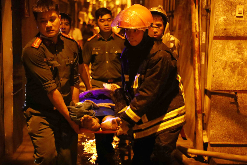 Lực lượng chức năng đưa nạn nhân ra khỏi hiện trường. (Ảnh: Phạm Kiên/TTXVN)