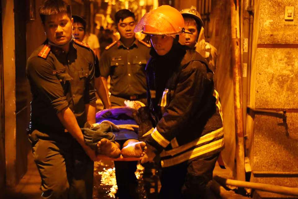 Lực lượng chức năng đưa nạn nhân ra khỏi hiện trường. (Ảnh: Phạm Kiên/TTXVN)