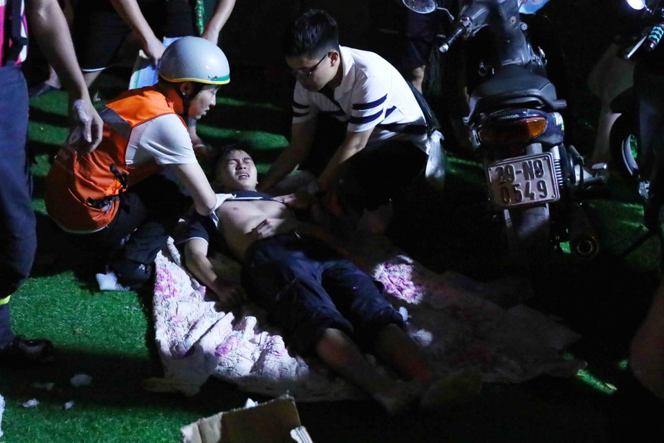 1 chiến sỹ Phòng cháy Chữa cháy bị thương được các nhân viên y tế sơ cứu. (Ảnh: Phạm Kiên/TTXVN)