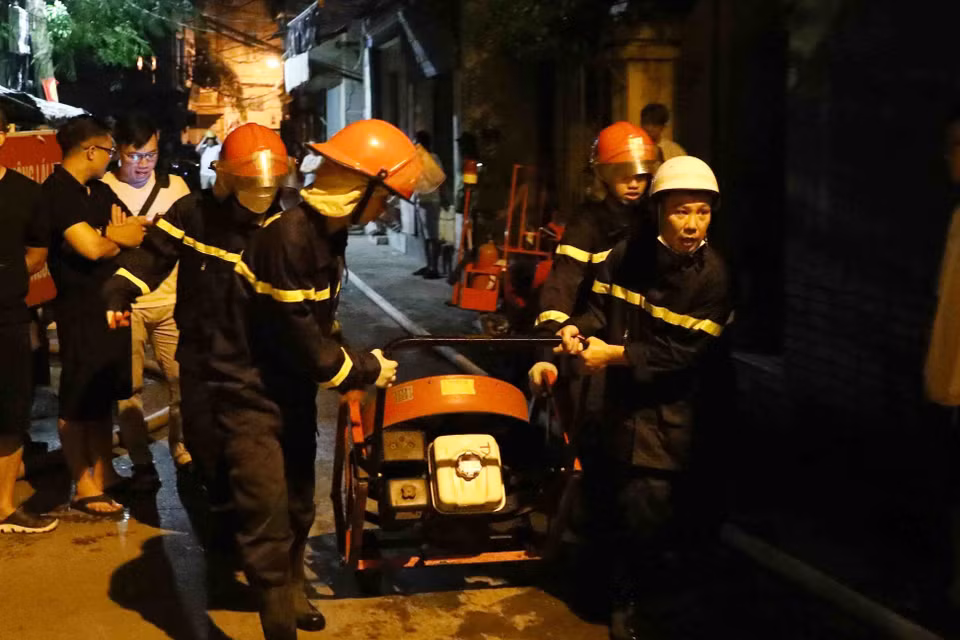 Lực lượng phòng cháy chữa cháy và cứu nạn cứu hộ đưa thiết bị chuyên dụng tiếp cận đám cháy. (Ảnh: Phạm Kiên/TTXVN)