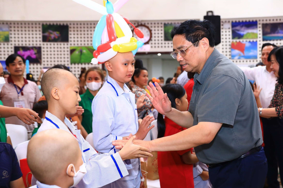 Thủ tướng Phạm Minh Chính thăm hỏi, động viên các bệnh nhi và người thân. (Ảnh: Hoàng Hiếu/TTXVN)