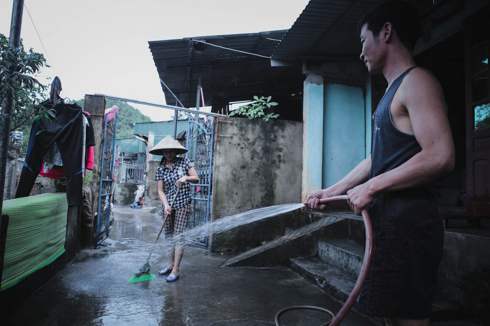 Mọi người dân trong các khu bị ngập hỗ trợ nhau dọn bùn đất. (Ảnh: Minh Sơn/Vietnam+)