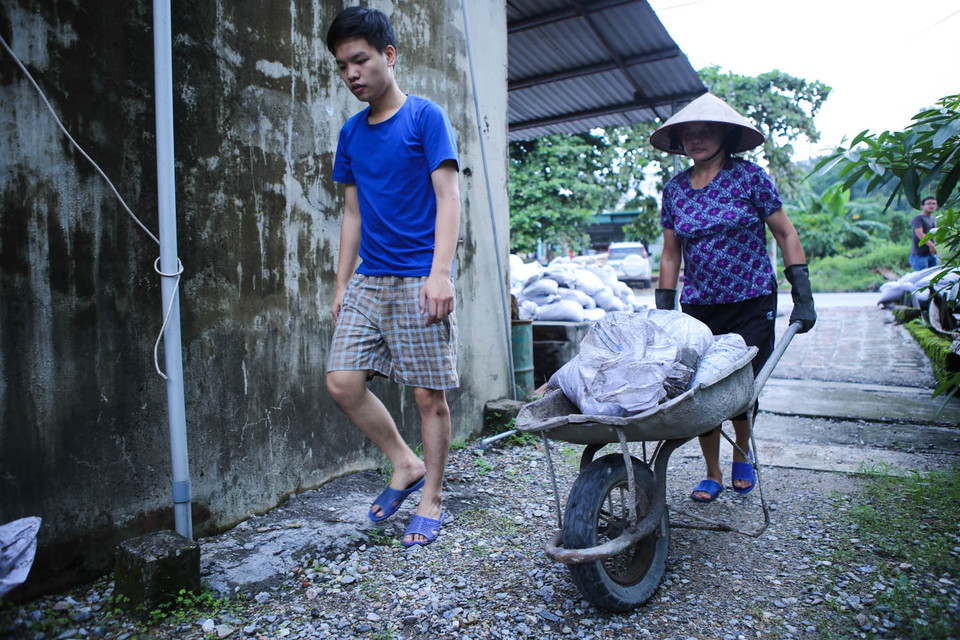 Một số gia đình quyết định lập ‘hàng rào’, gia cố căn nhà bằng những bao tải cát. (Ảnh: Minh Sơn/Vietnam+)
