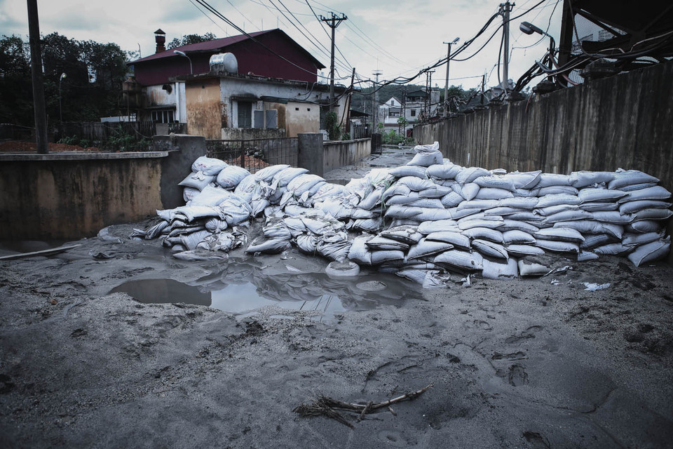 Hàng rào bao tải cát được dựng lên đề phòng lũ bùn có thể quay trở lại. (Ảnh: Minh Sơn/Vietnam+)
