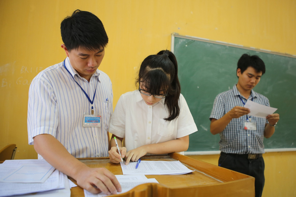 Cán bộ hướng dẫn sẽ ghi xác nhận những sai sót về họ, tên, đối tượng, hộ khẩu thường trú, khu vực của thí sinh và chuyển những thông tin này cho ban thư ký hội đồng thi xem xét, cập nhật vào phần mềm quản lý thi. (Ảnh: Minh Sơn/Vietnam+)