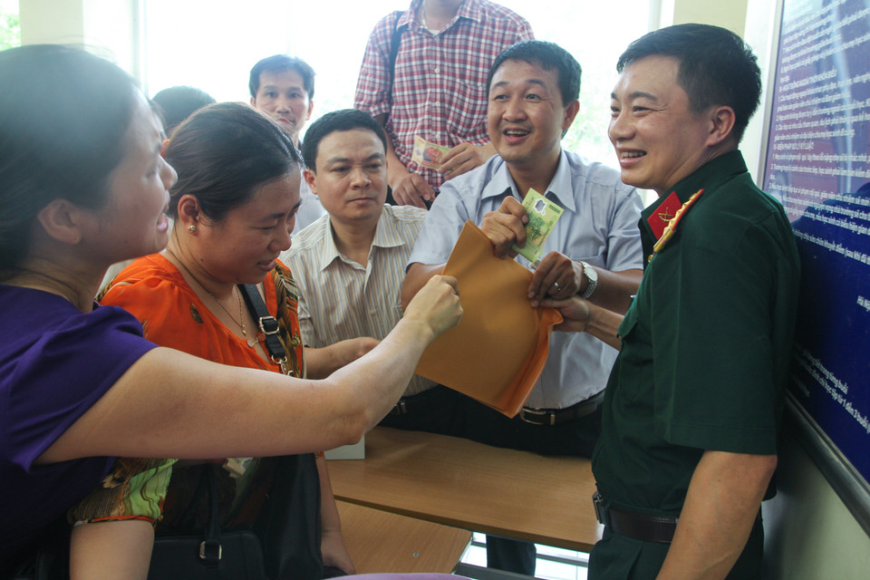 Thậm chí khi mua được rồi vẫn bị phụ huynh khác giành giật. (Ảnh: Minh Sơn/Vietnam+)