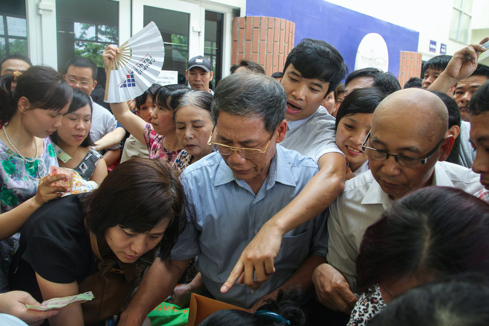 Các phụ huynh đã tự lập một danh sách hàng trăm người định đưa cho nhà trường để bán theo thứ tự người đến trước, đến sau. Tuy nhiên, khi chính thức mở bán, do lượng người rất đông nên trường không bán theo danh sách đã ghi, dẫn đến cảnh phụ huynh chen lấn, xô đẩy để mua. (Ảnh: Minh Sơn/Vietnam+)